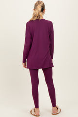woman wearing a long sleeve purple maternity tunic and matching leggings, facing away with a relaxed style