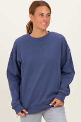 woman wearing a navy blue oversized sweatshirt with a relaxed fit and crew neckline, pairing with light gray sweatpants