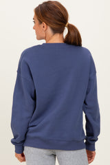 woman wearing a navy blue oversized sweatshirt, shown from the back, styled with gray sweatpants