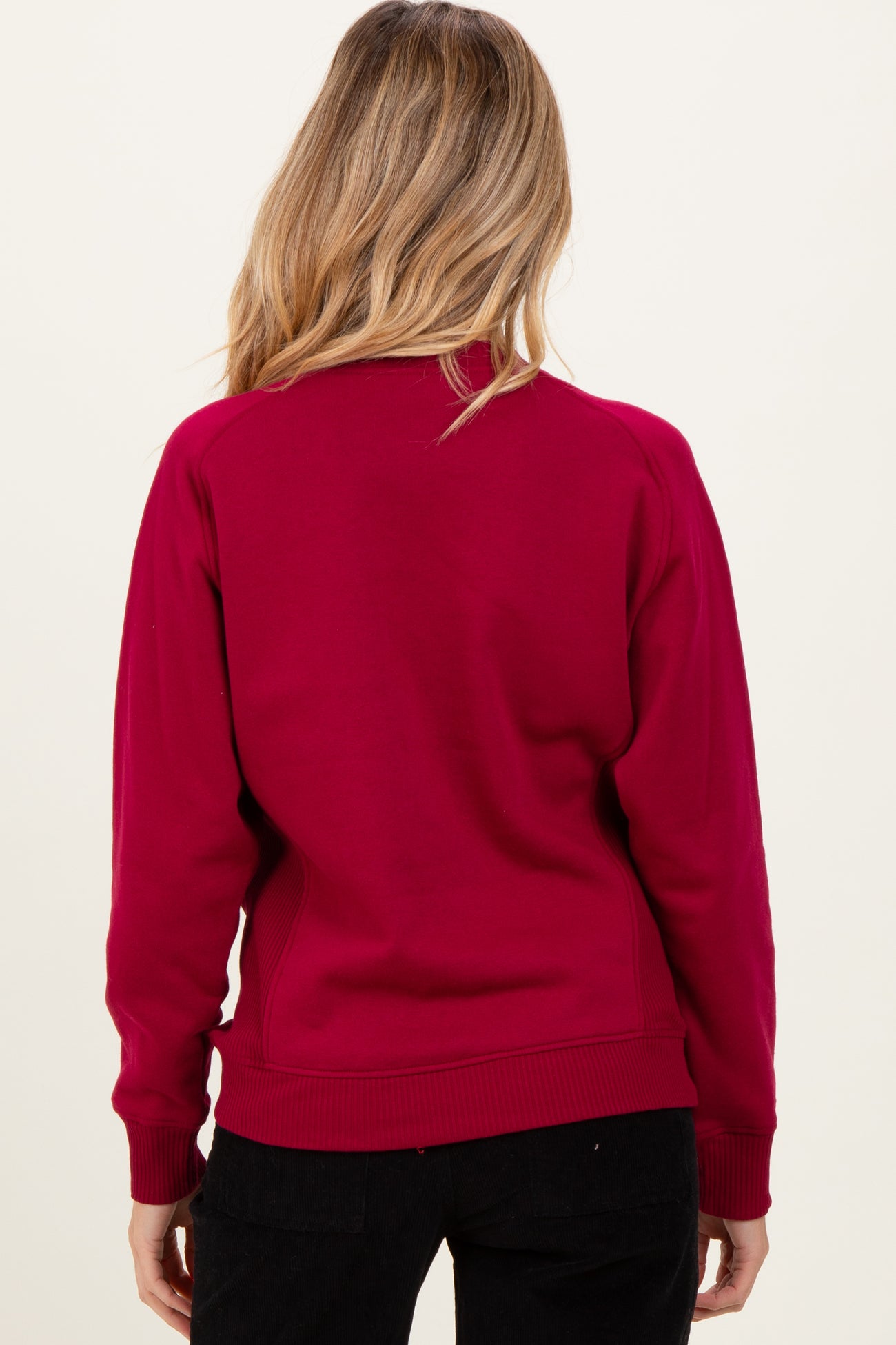 woman wearing a burgundy maternity sweatshirt, viewed from the back