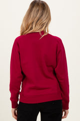 woman wearing a burgundy maternity sweatshirt, viewed from the back