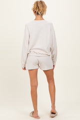 woman wearing a light grey long sleeve maternity top with matching shorts, seen from the back