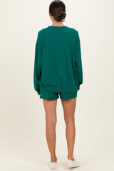 woman wearing a green oversized sweatshirt and matching shorts, seen from the back