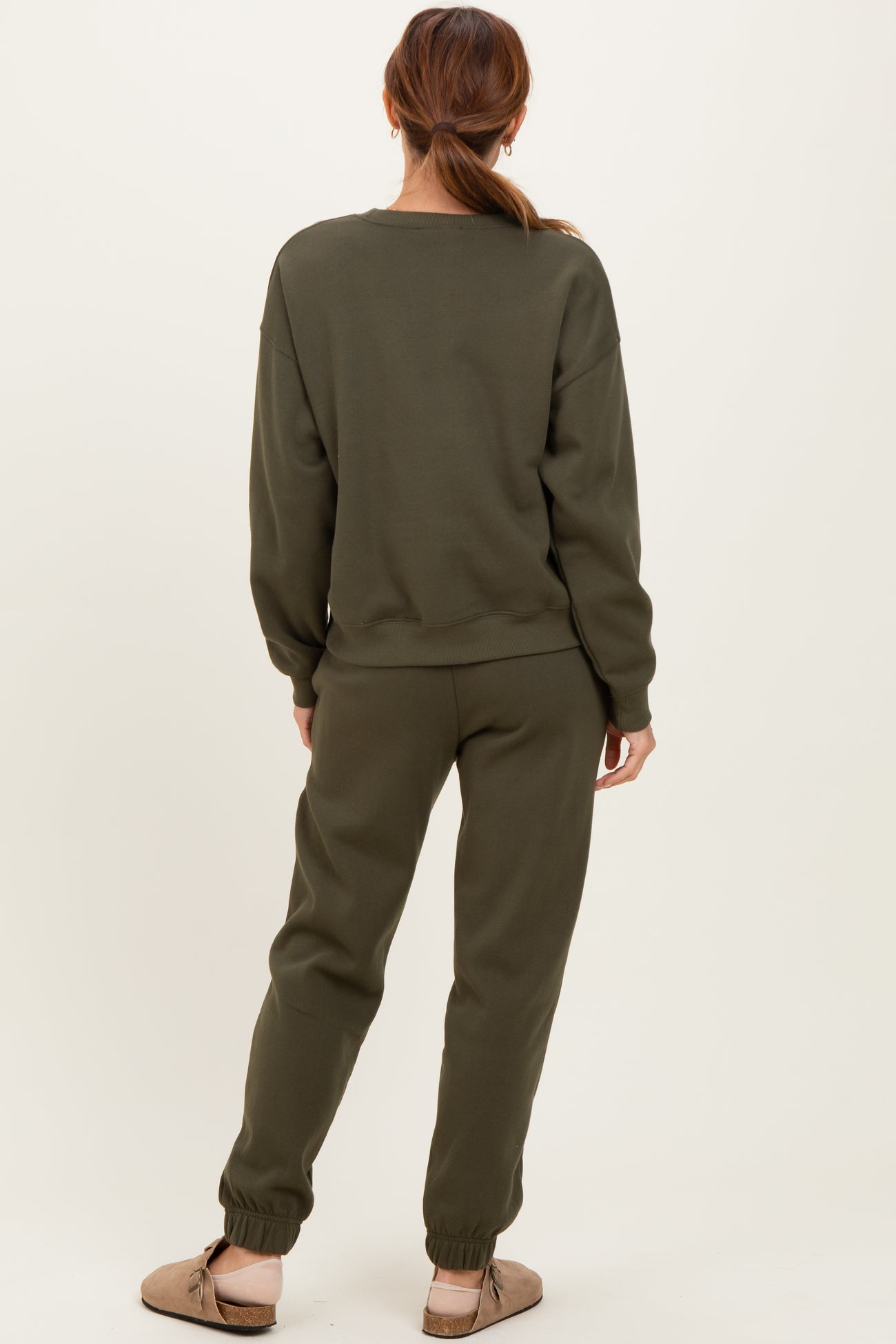 woman wearing an olive green oversized sweatshirt and matching joggers, with a relaxed fit and cuffed ankles