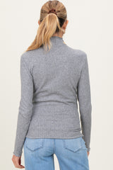 woman wearing a grey ribbed maternity turtleneck top, viewed from the back with long sleeves and a fitted style
