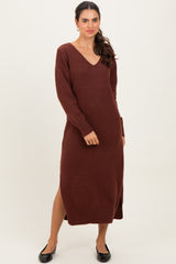 woman wearing a brown v-neck long sleeve sweater dress with side slits and a relaxed fit