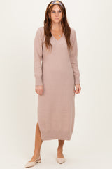 woman wearing a light pink knitted long sleeve v-neck dress with ribbed details and a relaxed fit