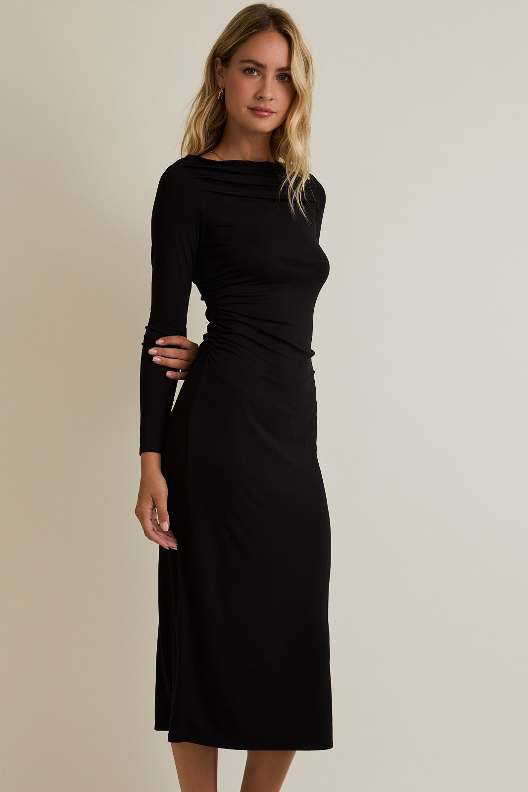 woman wearing a black long sleeve midi dress with a gathered side detail
