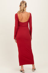 woman wearing a red long sleeve maternity dress with an open back and a fitted silhouette
