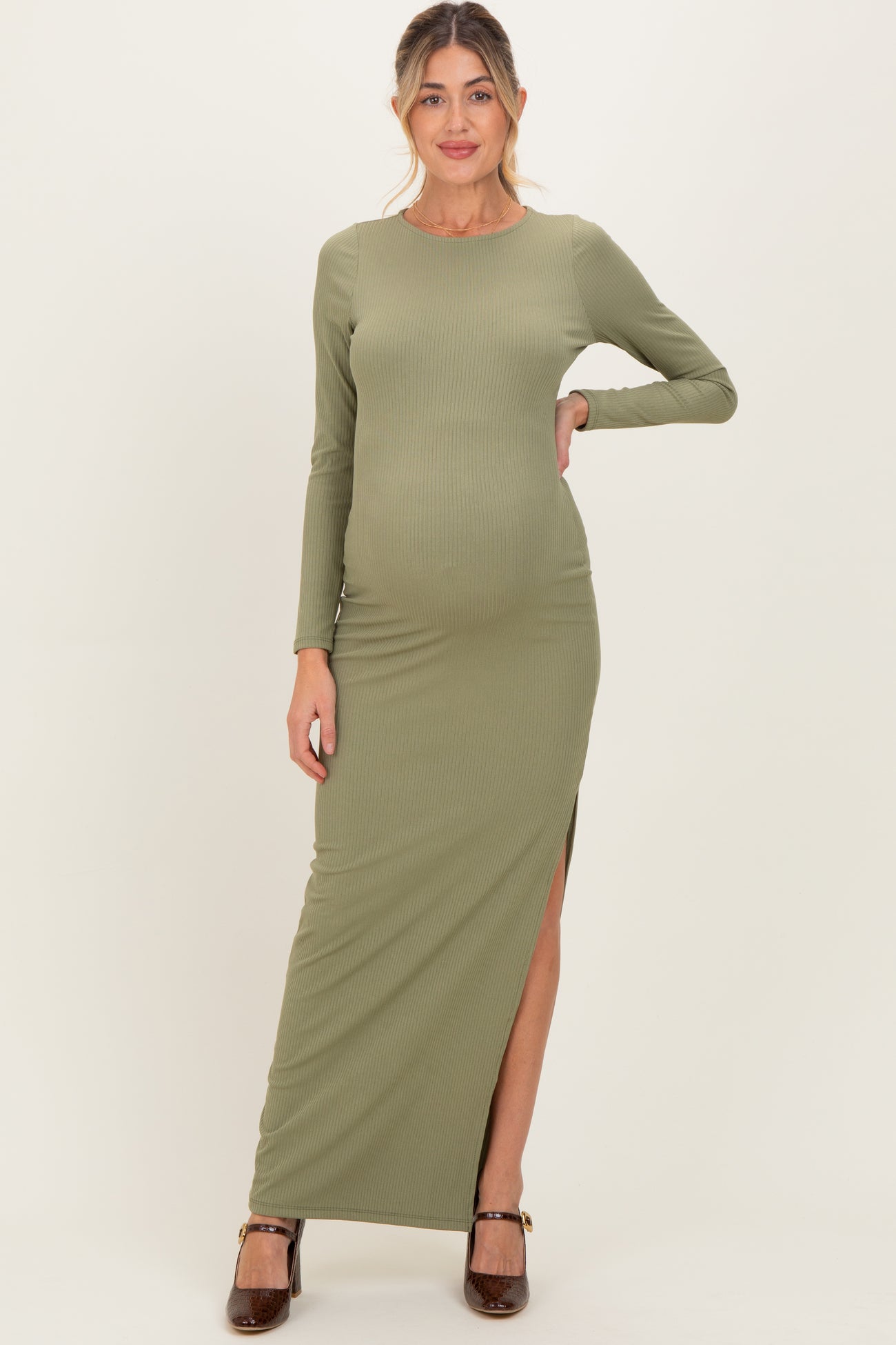 woman wearing a long green ribbed maternity maxi dress with a thigh-high slit and showing her baby bump