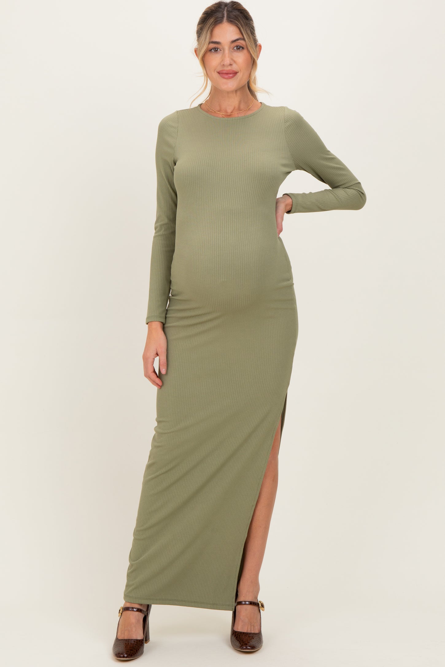 woman wearing a long green ribbed maternity maxi dress with a thigh-high slit and showing her baby bump