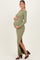woman wearing a green ribbed long sleeve maternity dress with side slits and holding her baby bump