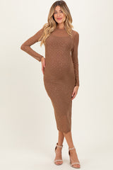woman wearing a brown long sleeve maternity dress with sparkly details and a visible baby bump