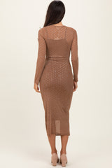 woman wearing a brown long sleeve midi dress with polka dot pattern and a fitted silhouette