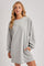 woman wearing a gray long sleeve sweatshirt dress with side pockets
