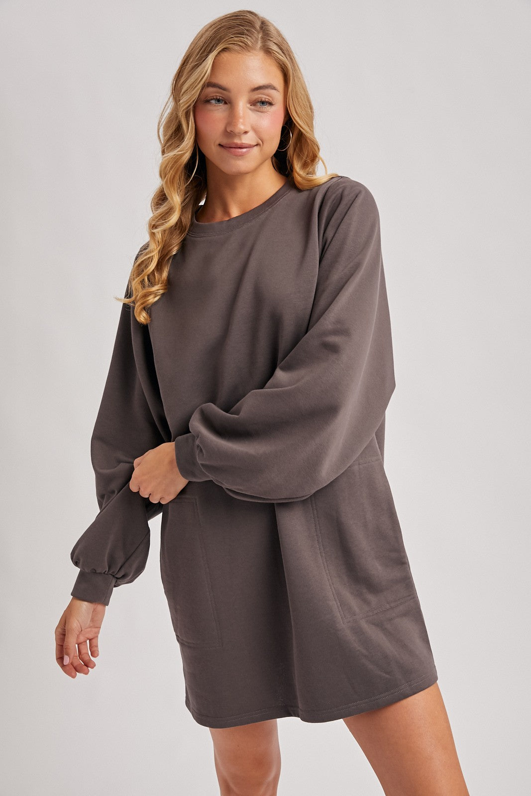woman wearing a charcoal gray long sleeve oversized sweatshirt dress with balloon sleeves