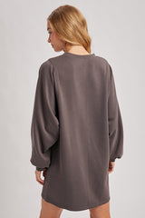 woman wearing a relaxed fit charcoal grey long sleeve sweatshirt dress with balloon sleeves, seen from the back