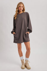 woman wearing a gray oversized sweatshirt dress with side pockets and long sleeves, paired with beige combat boots and knit socks
