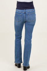 woman wearing blue flared maternity jeans, shown from the back, with a stretchy black maternity waistband