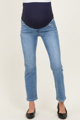 woman wearing blue maternity jeans with a dark blue over-the-bump panel and slim fit style