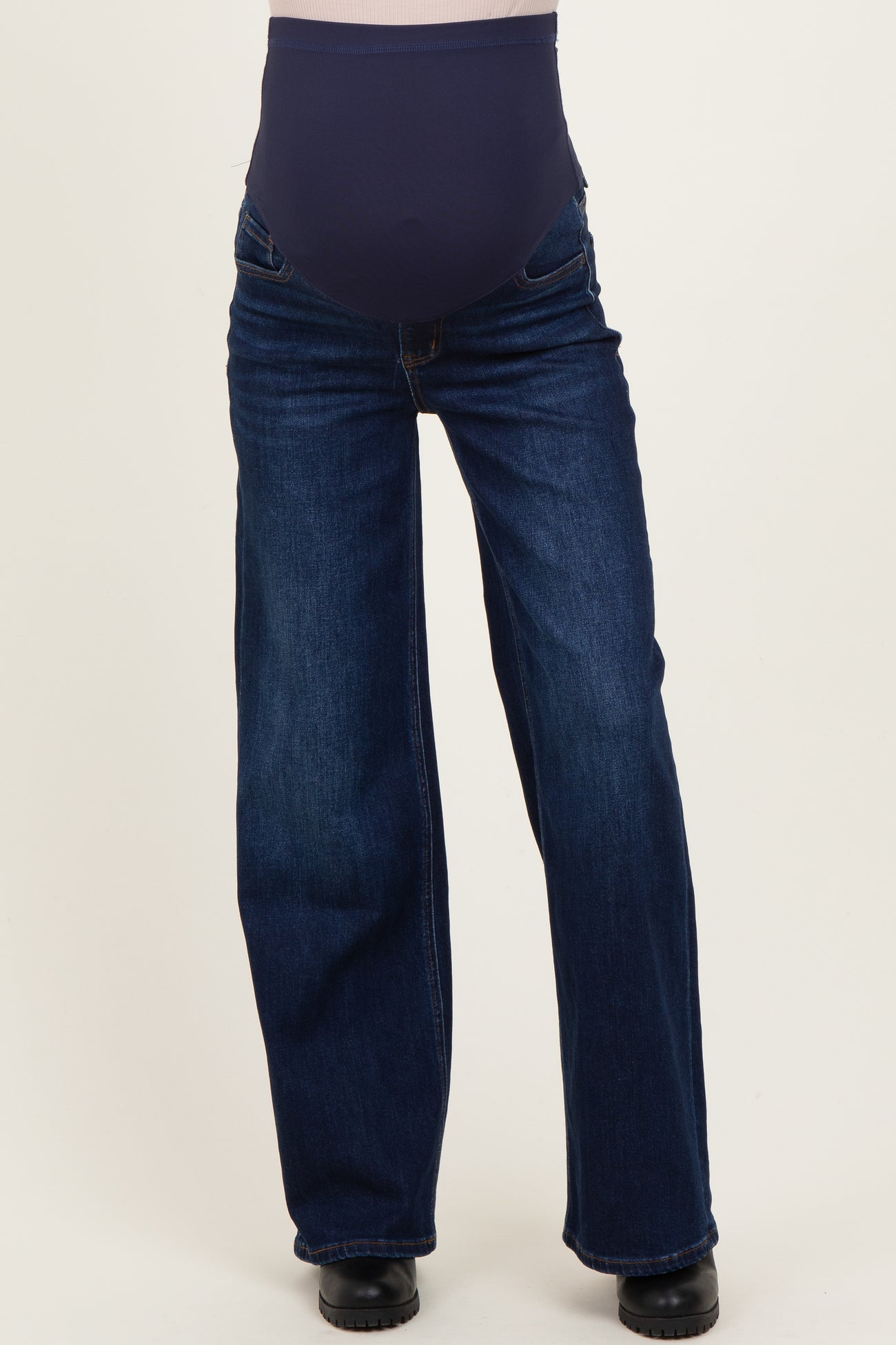 maternity wear dark blue straight leg jeans with a navy supportive belly band, model standing straight on a neutral background