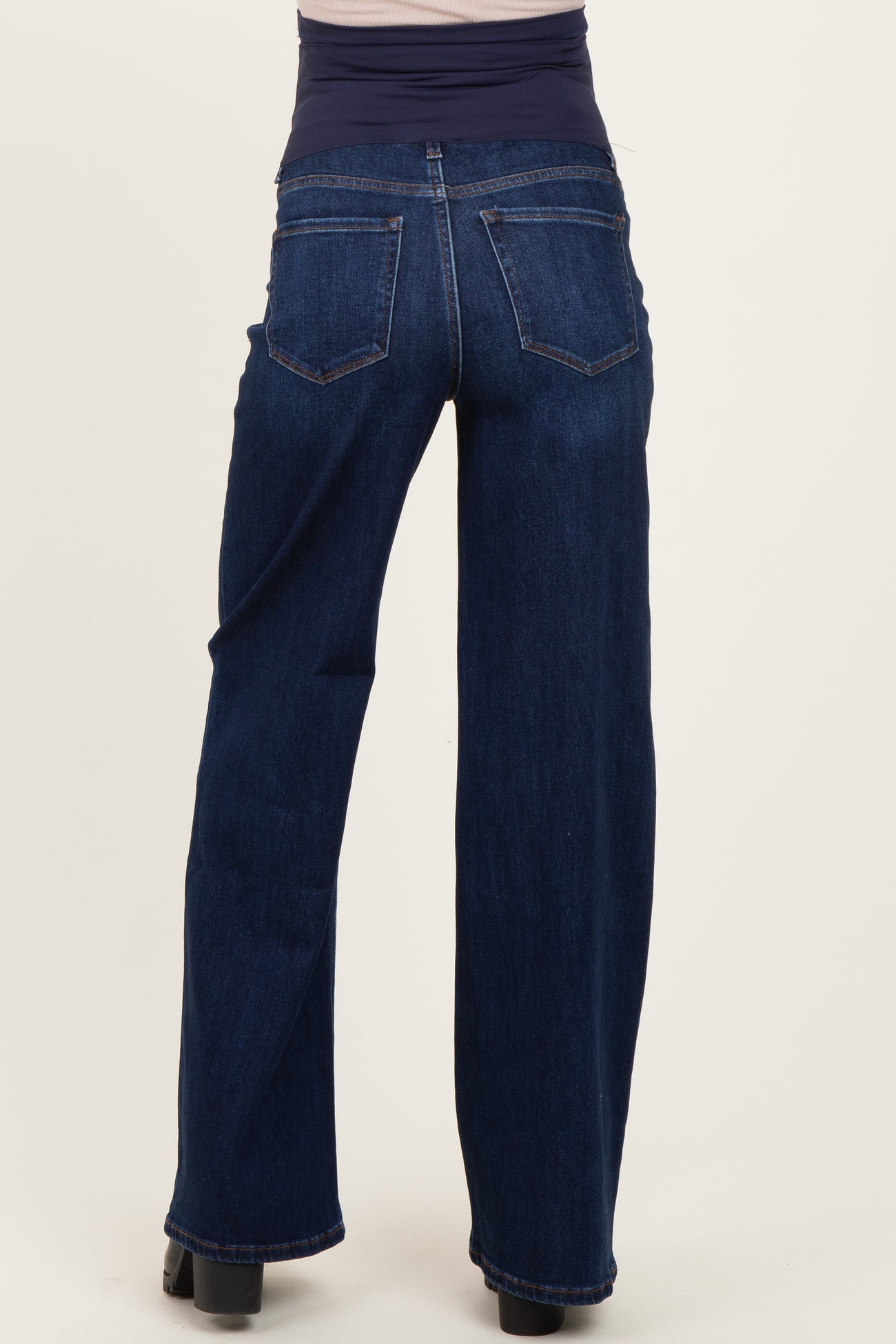 woman wearing dark blue maternity jeans with a wide waistband seen from the back
