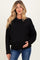 woman wearing a black maternity sweater with cable knit sleeves, holding her baby bump