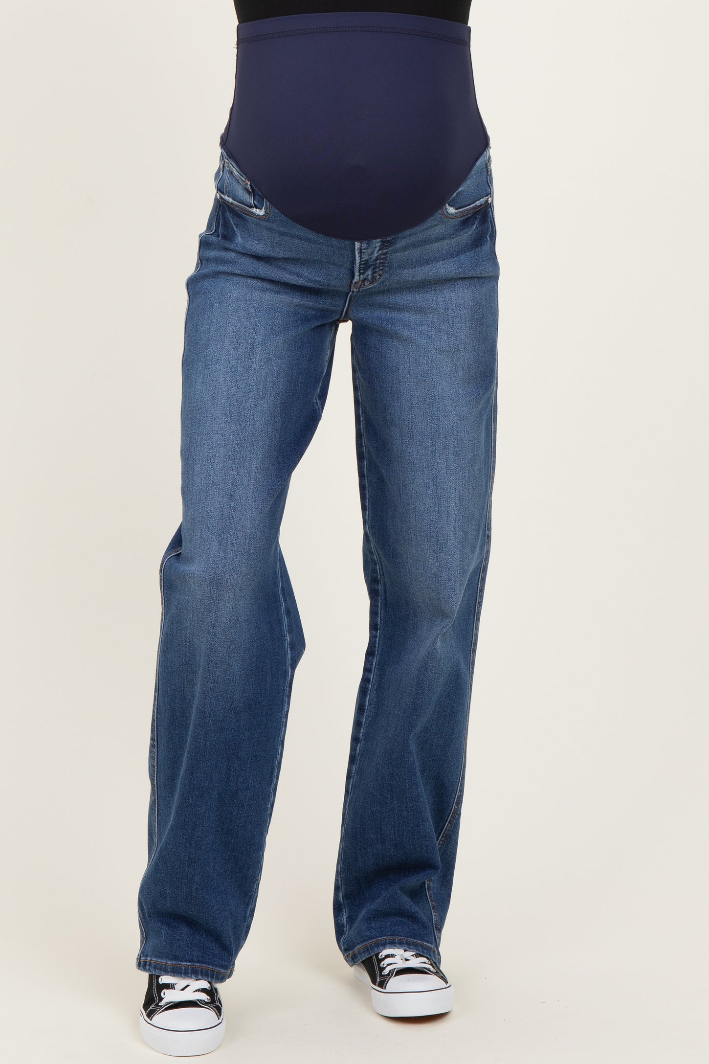 woman wearing a pair of dark blue maternity jeans with a stretchy belly panel and wide legs