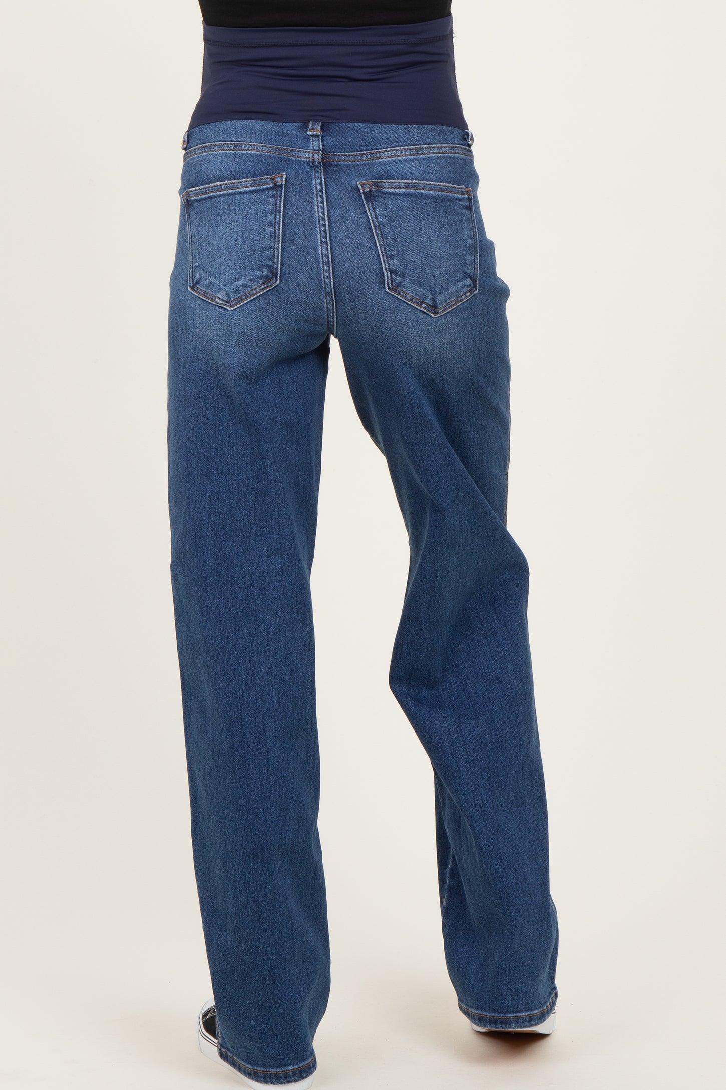 woman wearing maternity blue jeans with a relaxed fit and a supportive waistband, viewed from the back