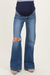 woman wearing distressed bootcut maternity jeans with a navy belly panel