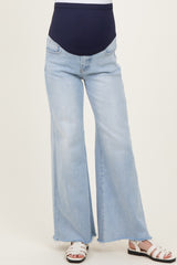 woman wearing light wash maternity flared jeans with a navy blue over-the-bump waistband