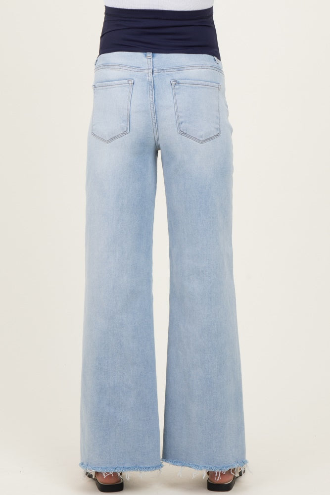 woman wearing light blue maternity wide-leg jeans with a raw hem and a navy blue waistband
