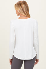 woman wearing a white long sleeve maternity top, shown from the back with a relaxed fit and curved hem