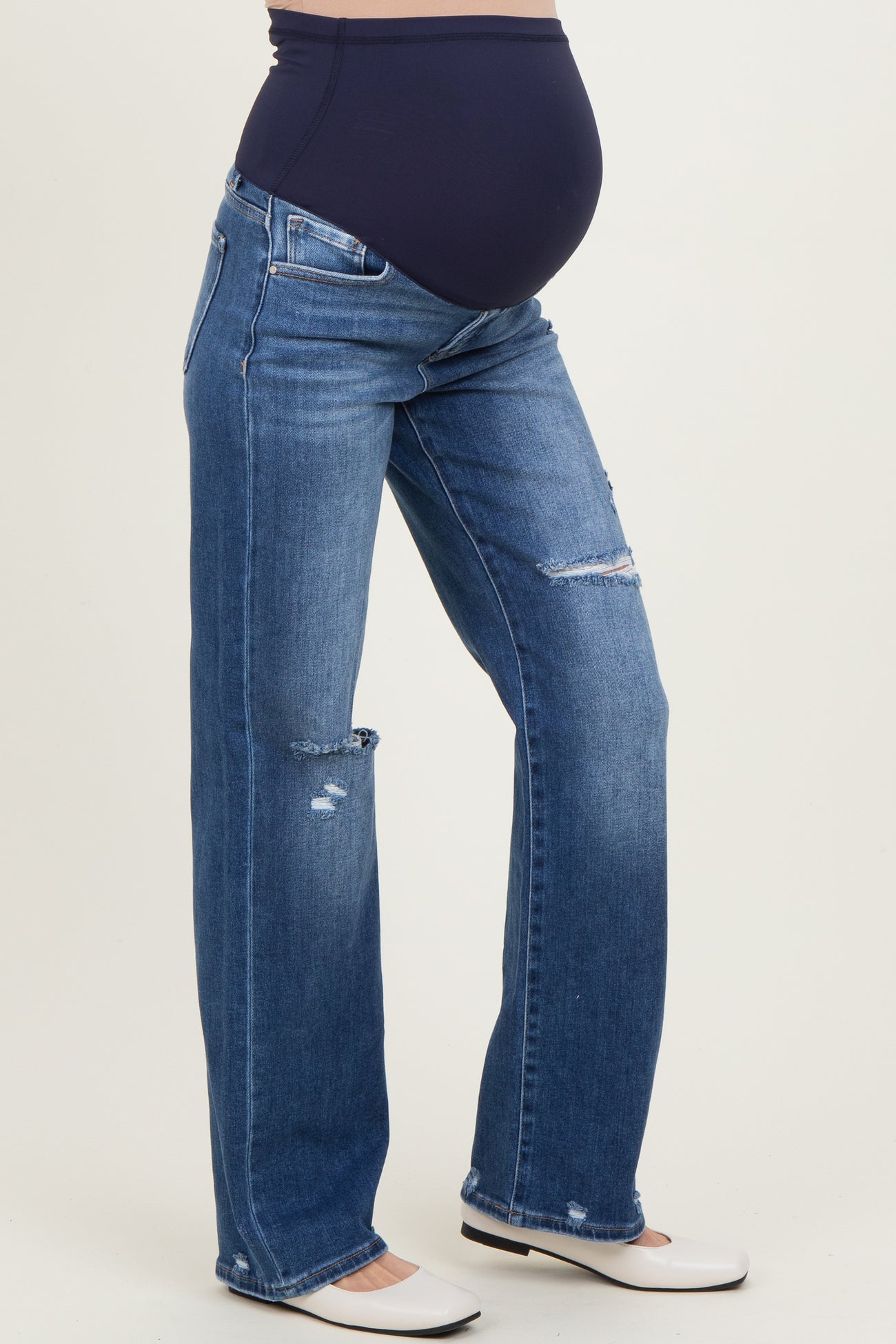 maternity wear dark wash distressed straight leg jeans with a stretchy belly panel, model showing her baby bump