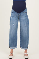 woman wearing a pair of light blue distressed maternity jeans with a wide leg and cuffed hem