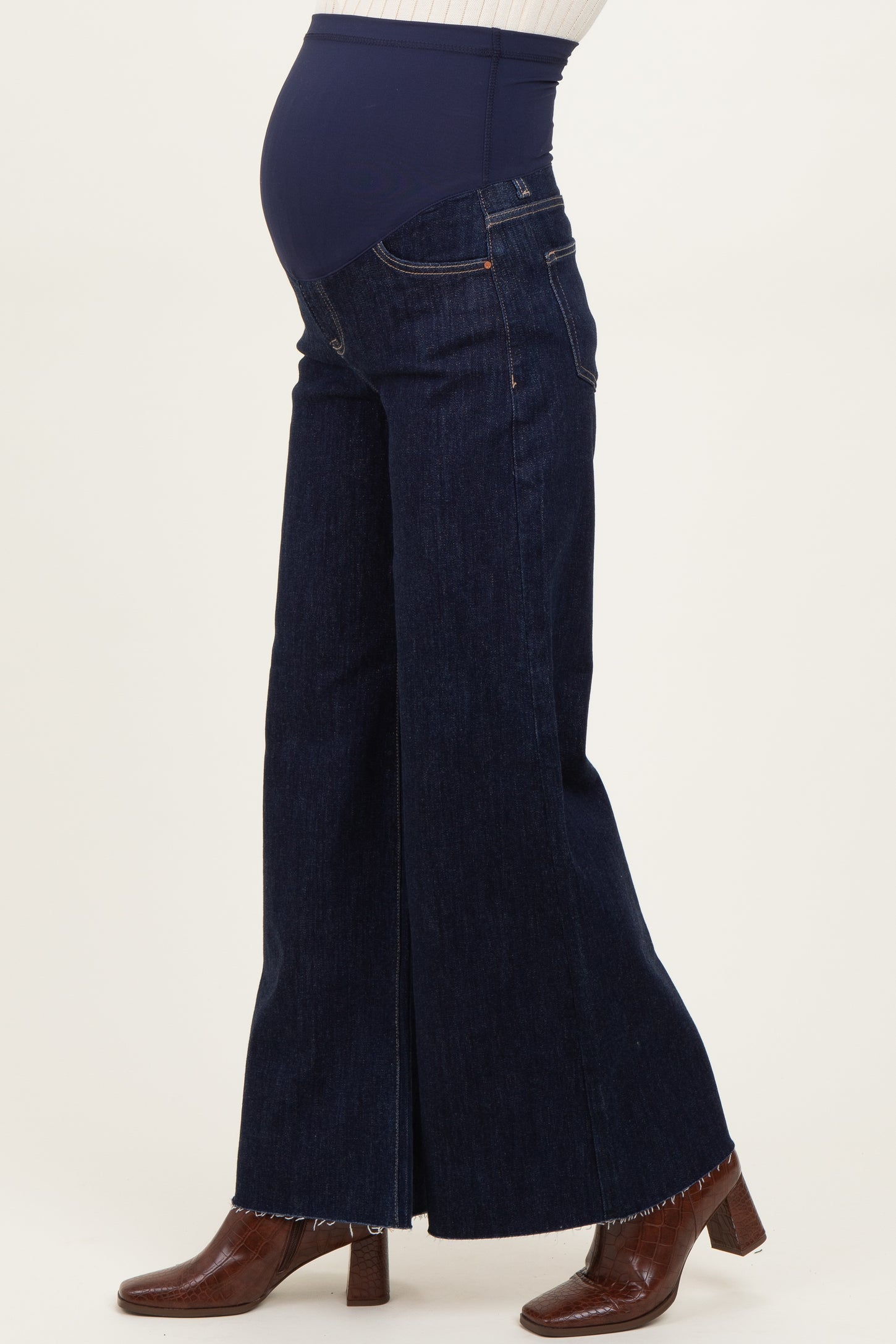 woman wearing dark blue maternity wide-leg jeans with a supportive belly panel and a visible baby bump