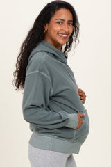 woman wearing a grey maternity hoodie with a front pocket and a visible baby bump