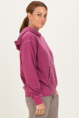 woman wearing a raspberry pink oversized hoodie with a front pouch pocket and hood