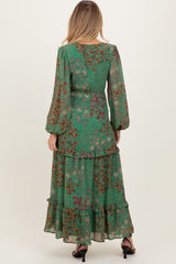 woman wearing a green floral maternity maxi dress with long sleeves and ruffle details