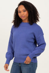 woman wearing a purple oversized sweater with balloon sleeves and a ribbed hem, paired with jeans