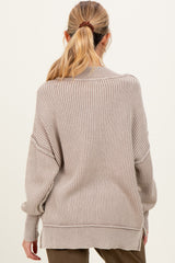 woman wearing a cozy beige striped maternity sweater with a relaxed fit and dropped shoulders, viewed from the back