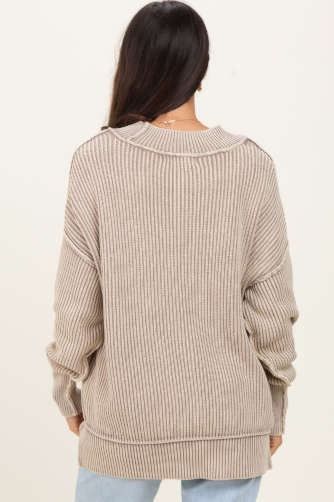 woman wearing a beige ribbed oversized sweater with a relaxed fit