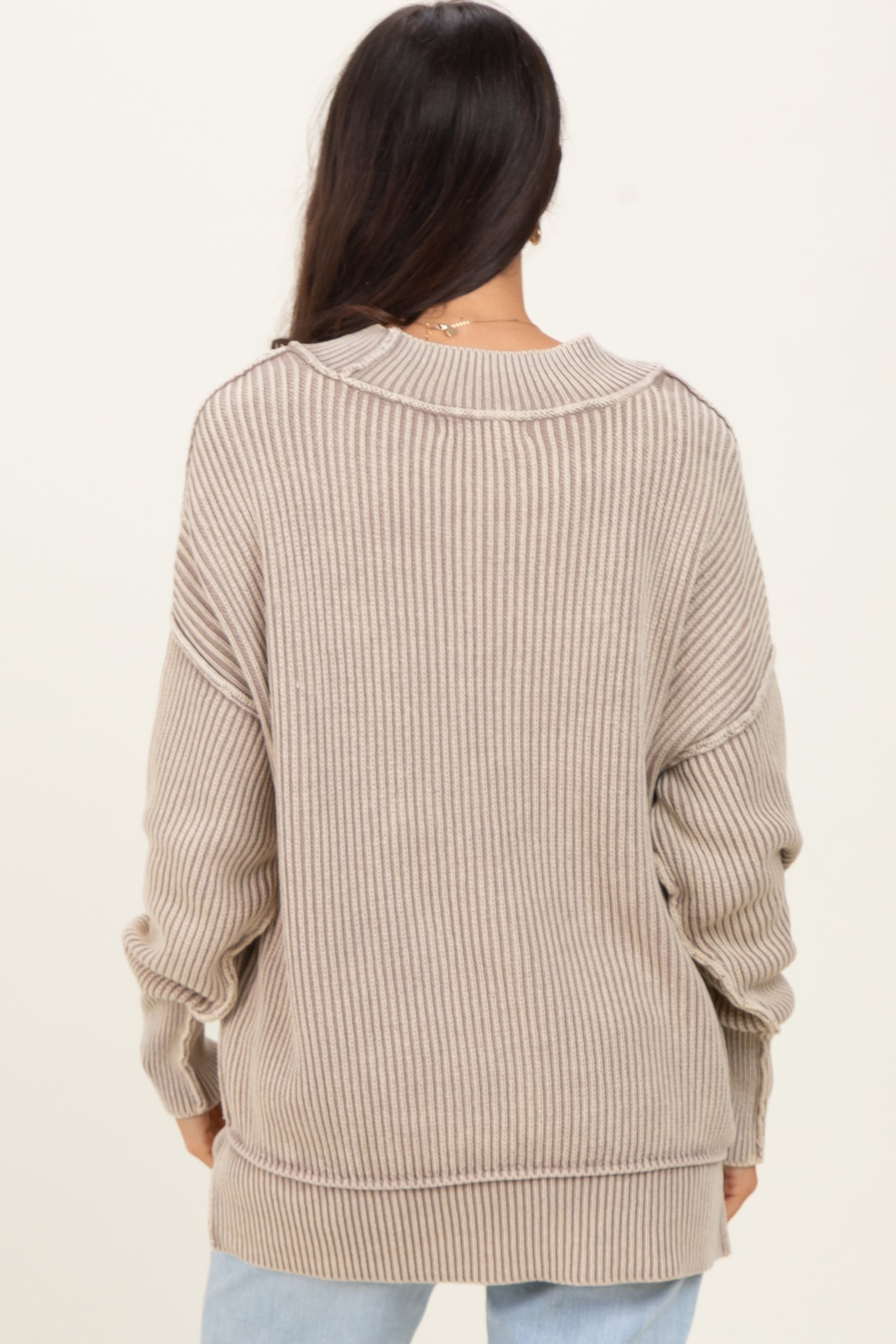 woman wearing a beige ribbed oversized sweater with a relaxed fit
