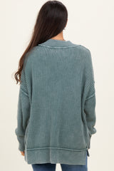 woman wearing a dark teal ribbed long sleeve oversized sweater with side slits and a relaxed fit
