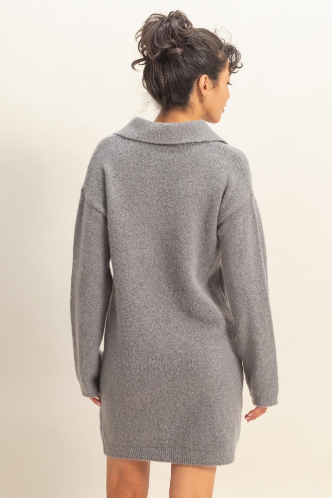 woman wearing a grey oversized sweater dress with a collar viewed from the back