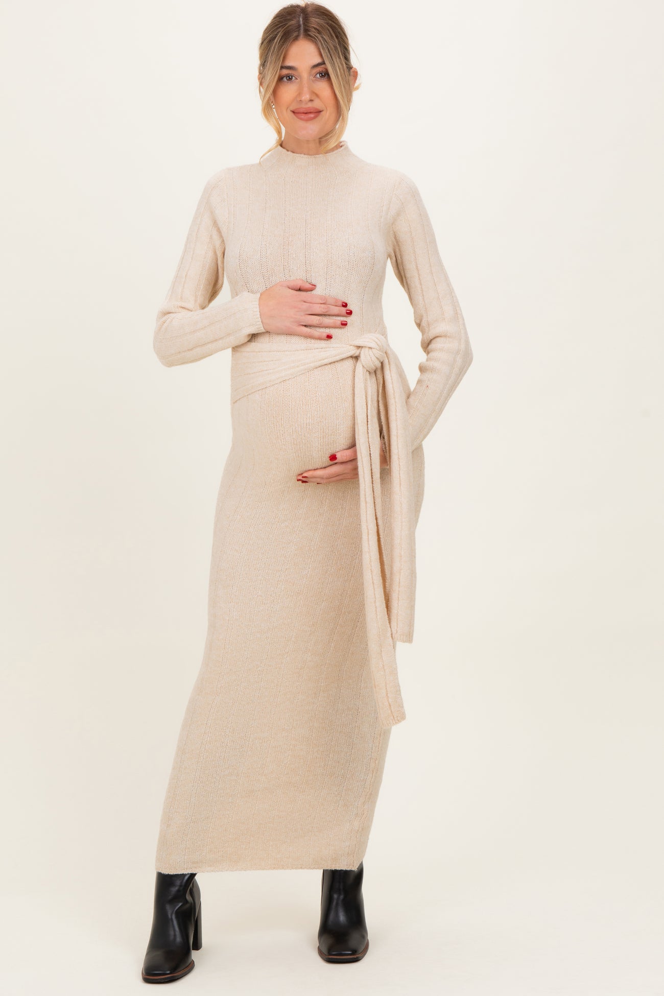 woman wearing a beige ribbed maternity maxi dress with a tie waist, showcasing her baby bump