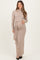 woman wearing a beige ribbed long sleeve maternity dress with a tie waist and visible baby bump