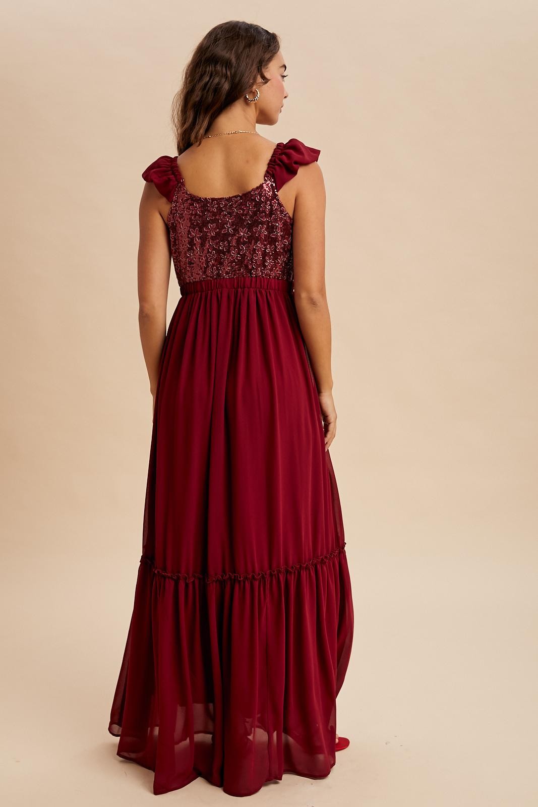 woman wearing a burgundy maxi dress with ruffle straps and a tiered skirt, showing the back view