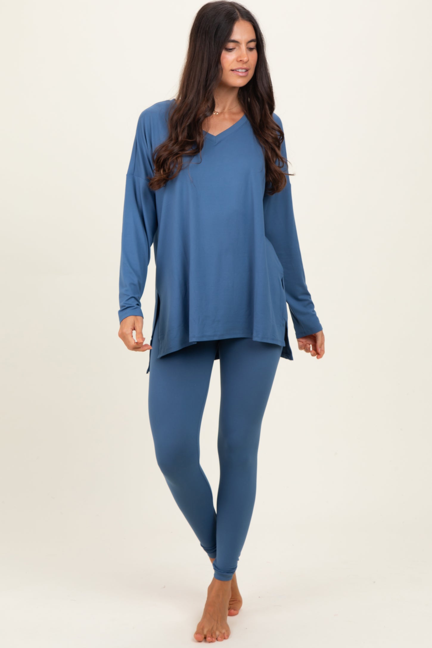woman wearing a blue long sleeve v-neck top with side slits and matching fitted leggings