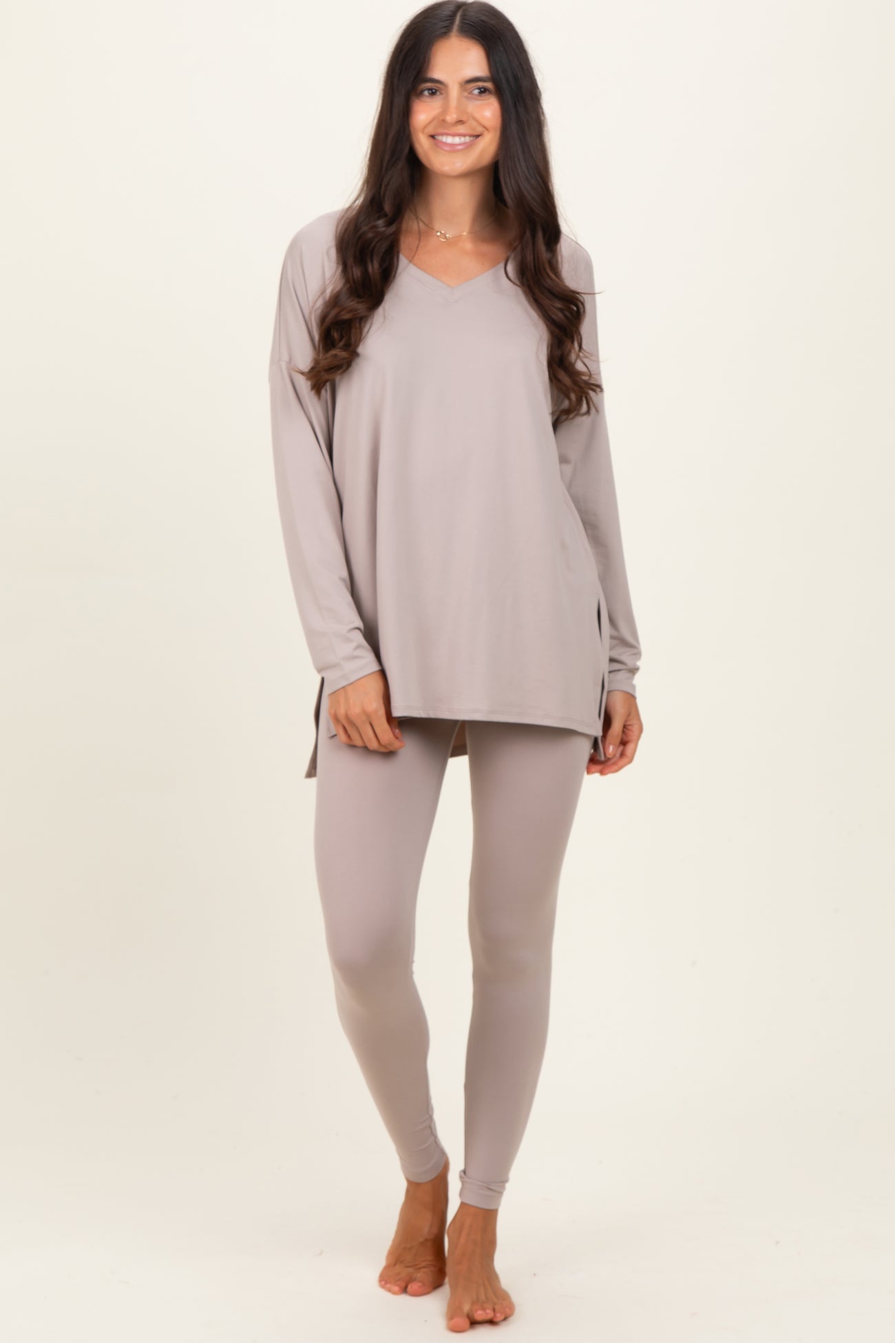 woman wearing a light taupe long sleeve v-neck top and matching leggings